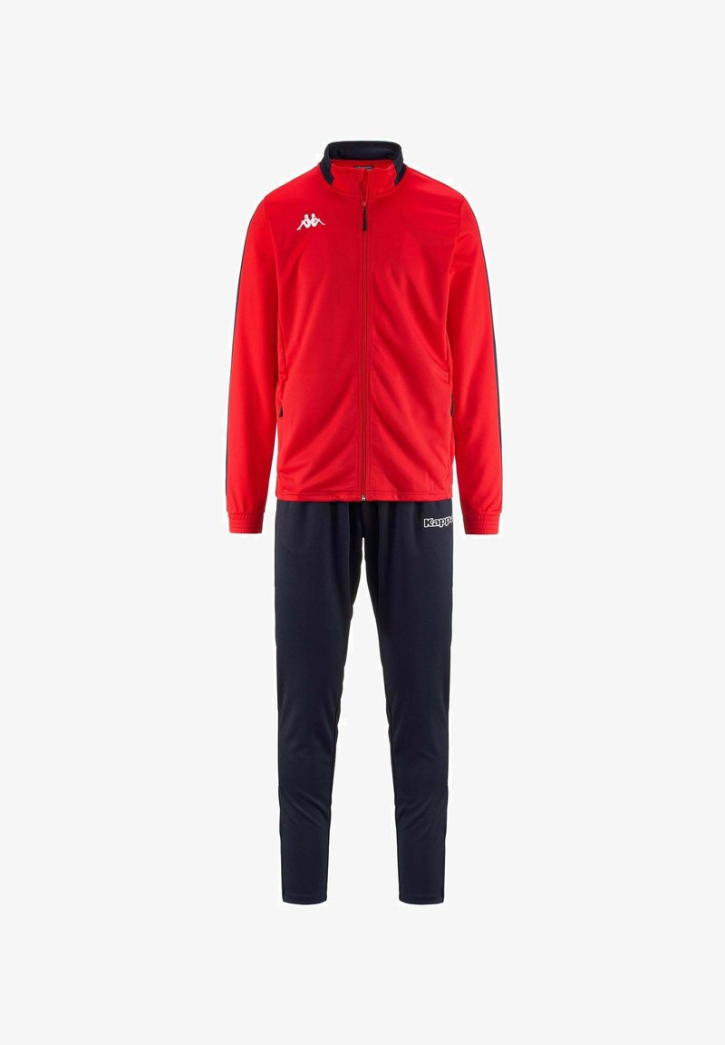 Giacca a zip rossa da atletica con colletto alto, abbinata a pantaloni blu navy. Presenta dettagli neri e un logo bianco sulla giacca. Texture liscia.