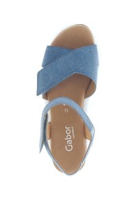 Modré džínové sandály s křížovými popruhy a béžovou polstrovanou stélkou. Design obsahuje boční kotníkový popruh pro podporu. Název značky je viditelný.