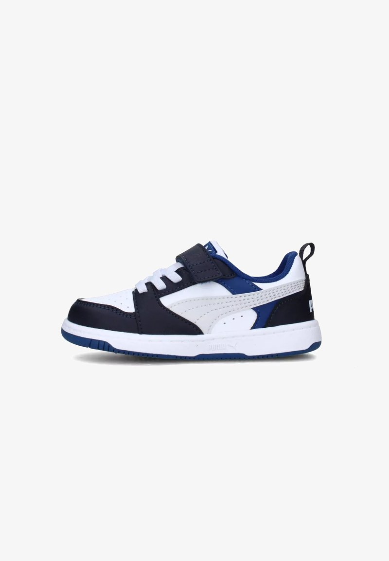 Sneakers bianchi e blu navy con una fascia in velcro, dettagli perforati e suola in gomma. Presentano un accento blu e il logo Puma sul tallone.