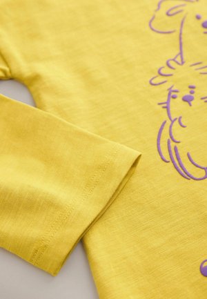Kollane puuvillane pika varrukaga särk, millel on lilla loomamuster, sile tekstuur ja õmmeldud varrukaotsad koos sirge alusaga.