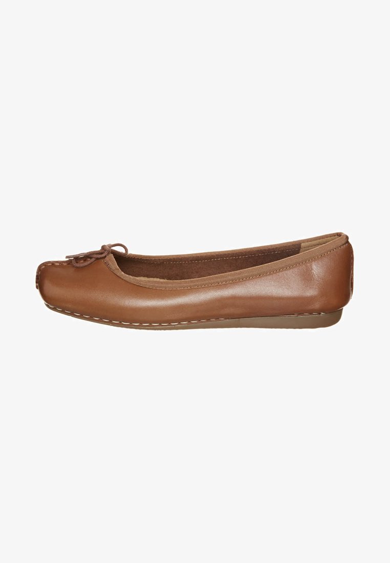 Brown leather ballet flat with a rounded toe, decorative bow at the front, and contrasting white stitching along the sole.