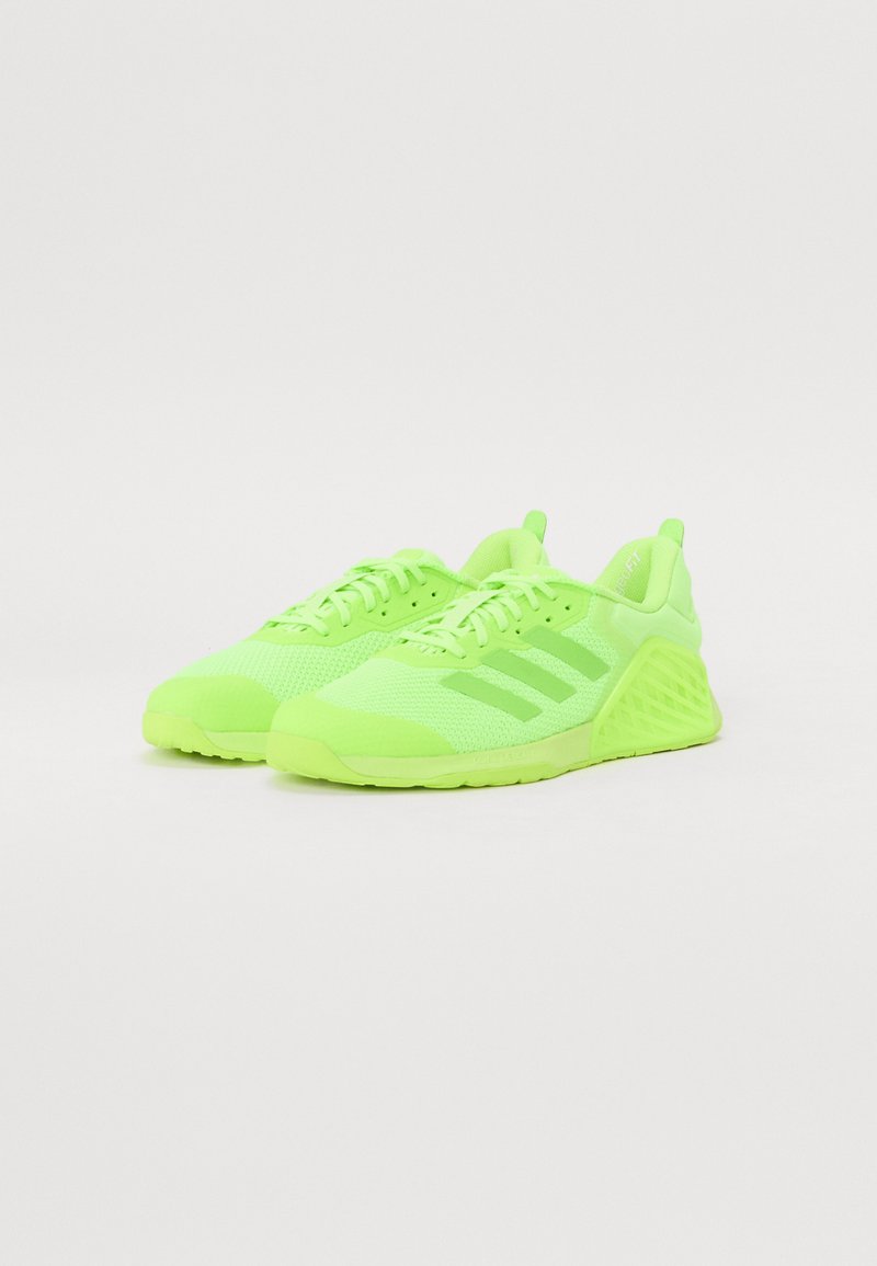 Scarpe da ginnastica in un vivace verde neon con tomaia in rete, accenti testurizzati, tre righe laterali e un design di suola geometrica distintivo.