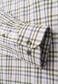 Karierte Bluse mit einer Mischung aus beige, grün und blauen Quadraten. Hergestellt aus einem Stoff mit glatter Textur und braunen Knöpfen an den Manschetten.