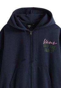 Marineblauwe zip-up hoodie van zacht materiaal met een vooraanstaande grafische opdruk "Vans OFF THE WALL®" in roze en groen. Voorzien van een trekkoord en zakken.