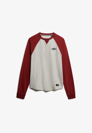 Langærmet raglantrøje med cremefarvet krop og mørkerøde ærmer, med teksten "SUPER DRY" på brystet og et lille mærke nær kanten.