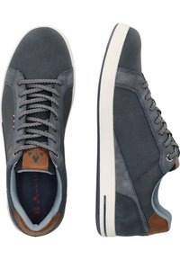 Miesten tennarit, joissa on tummansininen kangasosa harmailla yksityiskohdilla, ruskea nahkasauma kantapäässä ja valkoinen kumipohja; mukana harmaat nauhat.