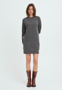 Gray long-sleeve dress made of soft fabric, featuring a round neckline and a relaxed fit, paired with brown knee-high boots.