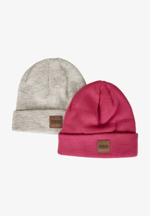 Dvě pletené čepice, jedna šedá s ohybem a logo nášivkou, druhá růžová, obě s měkkou texturou a přiléhavým designem.