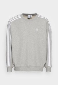 Grå sweatshirt gjord av bomullsblandat tyg. Har en vit tre-stripes design på axlarna, rund halsringning och en liten logga på bröstet.