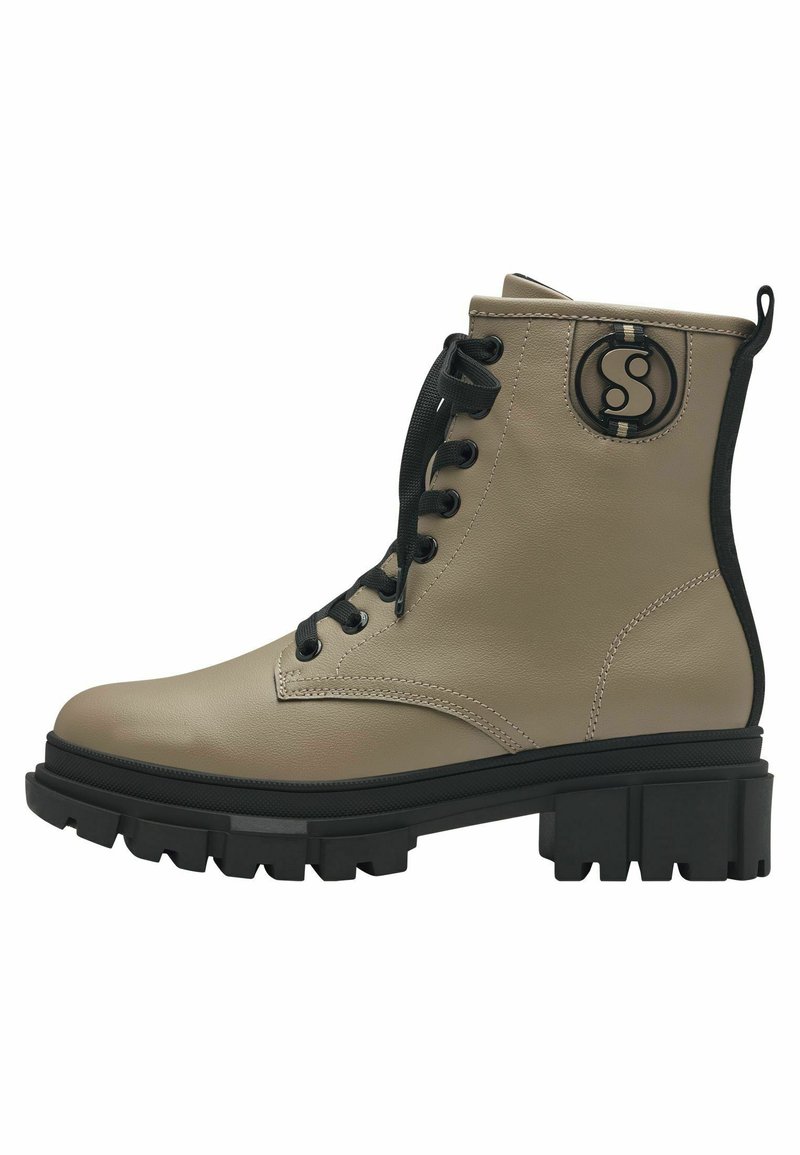 Bottines en cuir beige avec des lacets noirs, un accent de logo circulaire et une semelle noire épaisse dotée de rainures profondes pour une meilleure traction.