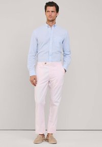 Camicia a maniche lunghe a righe blu chiaro e bianche; pantaloni rosa pallido; scarpe beige senza lacci; tessuto liscio; vestibilità slim.