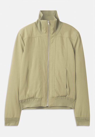Ανοιχτό πράσινο μπουφάν με ψηλό γιακά, φερμουάρ, ελαστικούς καρπούς και εφαρμοστό ζωνάκι. Λεπτό ύφασμα με διακριτές λεπτομέρειες ραφής.
