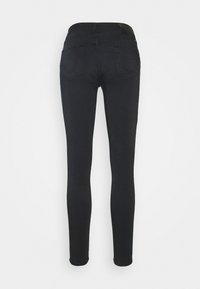 Jeans skinny negros con una tela suave y elástica. Cuenta con una cintura alta, dos bolsillos traseros y un pequeño parche negro con el logo en la parte posterior.
