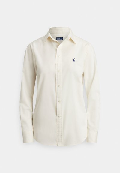 Kremfarget, langermet skjorte med knapper, krage og liten mørkeblå brodert Polo Ralph Lauren-logo på venstre bryst.
