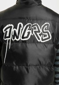 Sort puffer vest med stor hvid graffiti-stil tekst "ONGRS" på ryggen. Materialet ser glat ud med en blank overflade.