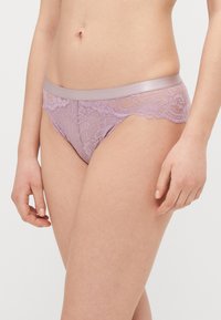Lavendel Spitzenunterwäsche mit einem glatten Satinbund, versehen mit filigranen Blumenmustern und gewellten Kanten. Geeignet für den täglichen Gebrauch.