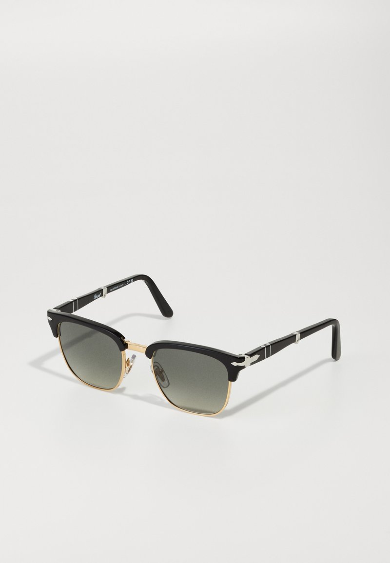 Black sunglasses with square lenses, gold metal frame accents, black plastic temples, and gray gradient lenses. Features nose pads for comfort.
