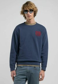 Felpa blu navy in cotone, con una grafica rossa sul petto, colletto e polsini a coste, e una vestibilità rilassata.