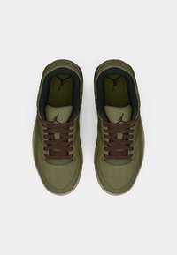 Zaļi zamša sporta apavi ar brūnām šņorēm un gumijas zoli. Uz mēles un iekšējām zolēm ir melns Jumpman logo. Apaļas formas purngali.