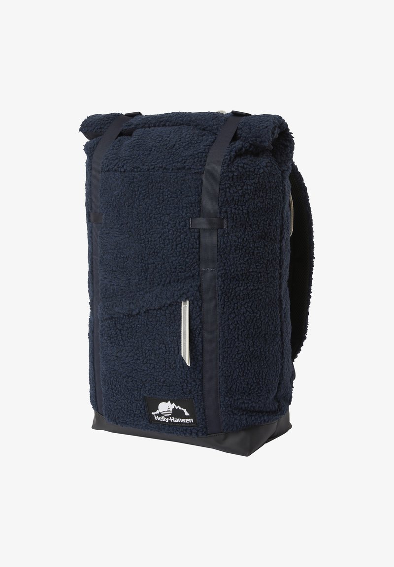 Sac à dos Helly Hansen bleu marine en tissu polaire avec fermeture à rabat roulé, bretelles noires et poche zippée à l'avant.