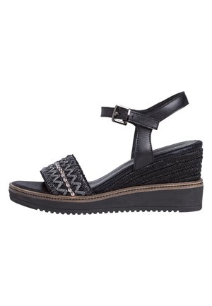 Sandale compensée noire avec plateforme tressée, bride de cheville réglable avec boucle et bride avant décorative avec perles.