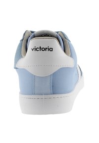 Sneaker azzurro chiaro con tomaia in tessuto testurizzato e suola in gomma bianca; presenta un'etichetta sul tallone con il marchio e finiture lisce.