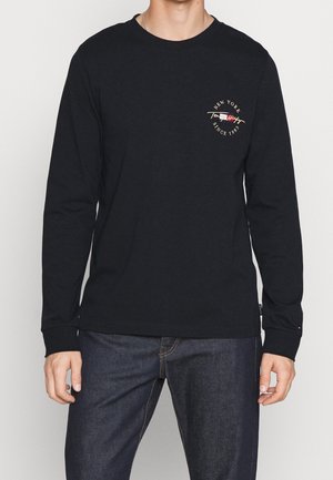 Langärmliges schwarzes Baumwollshirt mit Rundhalsausschnitt und einem kleinen roten und goldenen "New York Since 1985"-Grafik auf der Brust.