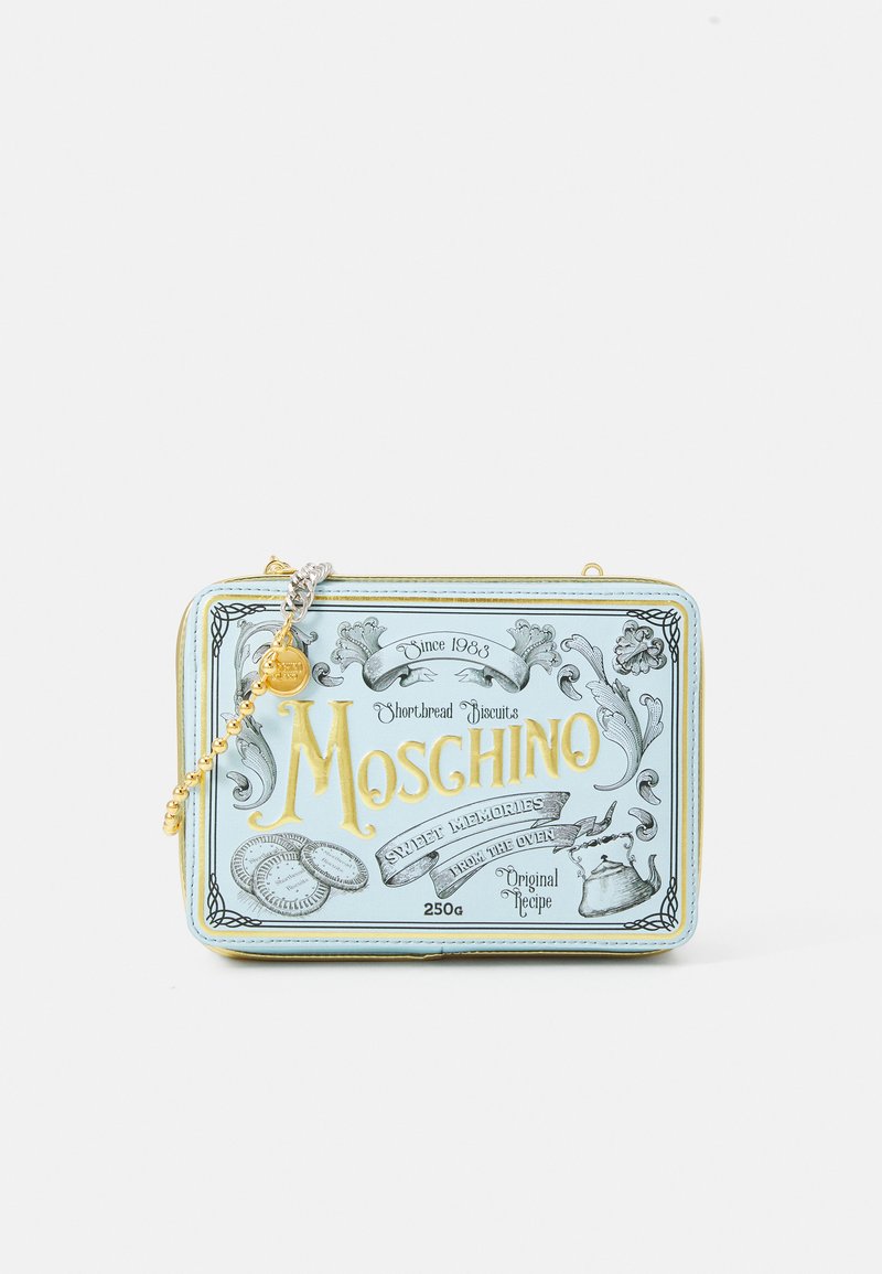 Sac à main rectangulaire bleu clair avec des accents dorés, des graphiques en relief et une bandoulière en chaîne, conçu pour ressembler à une boîte de biscuits.