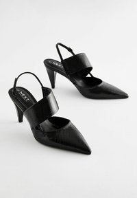Svarta slingbacks med spetsig tå i en texturerad ormskinnsmönster och bred rem över framfoten. Slank, kurvig klackdesign.