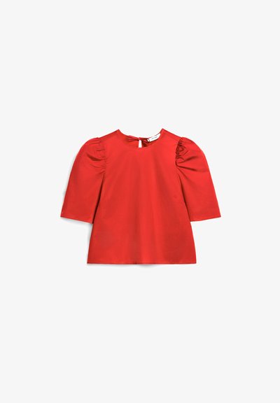 Czerwona bluzka z krótkim rękawem, z bufkowymi ramionami i małym dekoltem w kształcie klucza oraz kokardką z tyłu przy szyi.