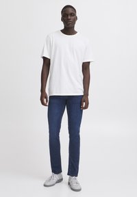 Witte katoen t-shirt, blauwe denim jeans en grijze sneakers, met een klassieke pasvorm, korte mouwen en een effen ontwerp zonder patronen.