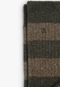 Calcetines de punto a rayas marrones y verdes oscuros con una textura acanalada, que presentan un pequeño logo de calavera en un costado.