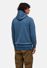 Blauwe hoodie met een ontspannen pasvorm, gemaakt van zachte stof. Bevat ribgebreide manchetten en een zoom, en zichtbare stiksels op de schouders.