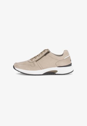 Beige suède sneaker met een laag profiel, veters en ritssluiting, witte tussenzool en zwarte rubberen buitenzool. Gladde textuur met minimale accenten.
