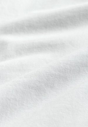 Biela bavlnená tkanina s hladkou textúrou a jemným, rovnomerným prešitím; materiál sa jemne spúšťa s jemnými záhybmi a vráskami.