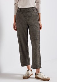 Grå rutiga byxor med hög midja, med en slät framsida och subtil textur. Kombineras med vita och beige sneakers.