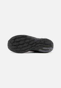 Schwarze Sportschuhsohle aus strukturiertem Gummi mit einem Muster aus kreisförmigen Akzenten für Grip und Flexibilität.