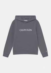 Sudadera con capucha gris que presenta un logo frontal "CALVIN KLEIN" en blanco, puños y dobladillo acanalados, con una tela suave y texturizada.