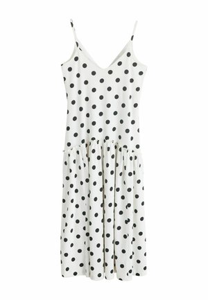 Biała sukienka bez rękawów w czarne kropki, dekolt w serek, marszczona talia i midi długości rozpływająca się spódnica.