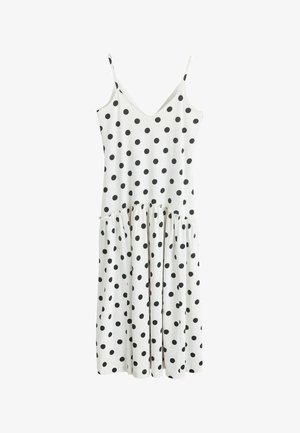 Hvid ærmeløs kjole med sorte polkaprikker, V-hals, indsnævret talje og midi-længde flydende nederdel.