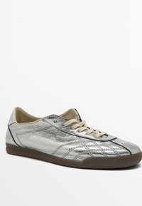 Baskets en cuir argenté avec finition texturée, lacets beige et semelle en caoutchouc marron. Caractérisées par un bout arrondi et des lignes de design simples.