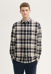Kariertes Button-Down-Shirt in Marineblau, Braun und Creme; aus weichem Stoff; mit einer einzelnen Brusttasche und einem klassischen Kragen.
