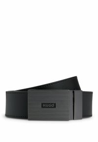Ceinture en cuir noir avec une boucle en métal noir texturé, affichant des lignes horizontales et un logo en relief. Finition avec un surpiquage contrastant.