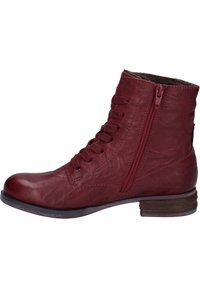 Botas de tobillo de cuero rojo con un acabado texturizado, que presentan un diseño de cordones en la parte frontal y una cremallera lateral. Tacón bajo de madera apilada.