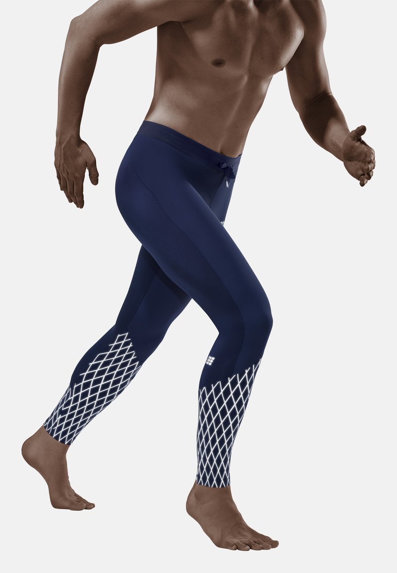 Marineblauwe sportlegging gemaakt van rekbaar materiaal, met een ruitpatroon in het wit op de onderste benen en een verstelbare tailleband.