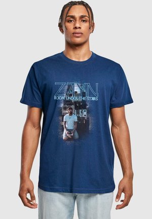 Navy cotton t-shirt featuring a graphic design with "ZAYN" and "ROOM UNDER THE STAIRS" text, and an image of a seated figure in front of audio equipment.