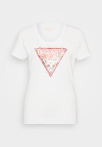 T-shirt de algodón blanco que presenta un gráfico triangular rosa con acentos florales y el texto "GUESS?" centrado dentro del triángulo.