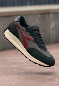 Men's sneaker with mixed materials in navy, grey, and burgundy, featuring a textured upper, padded collar, and rubber sole.