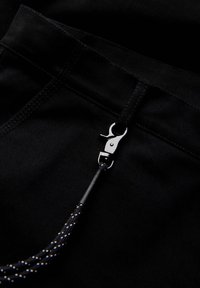 Černé kalhoty z látky se zapínáním na zip se stříbrným kovovým háčkem a černým pleteným šňůrkou pro funkčnost.