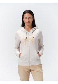 Lichtbeige rits hoodie met een voorlogo waarop "Spirit" in goud staat, voorzien van een koordkap, twee zijzakken en geribde manchetten.